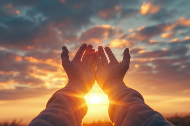 Las manos levantadas en adoración al cielo al atardecer