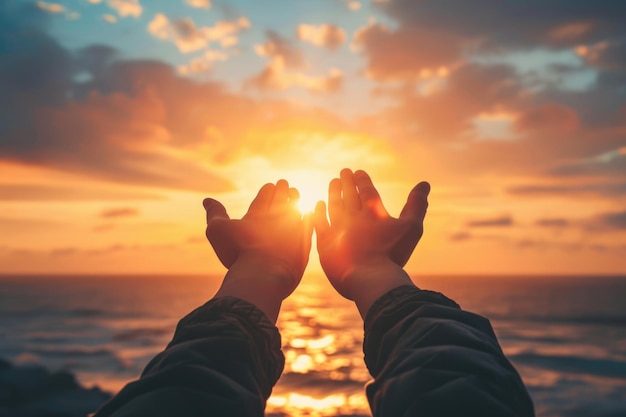 Las manos levantadas en adoración al cielo al atardecer