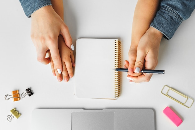 Manos de madre e hijo escribiendo en un bloc de notas