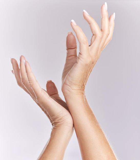 Manos de manicura suave o tratamiento de belleza primer plano de palmas modelo femeninas tocando en elegante pose de mano aislada sobre fondo de estudio púrpura Cuidado de las uñas cuidado de la piel o parte del cuerpo libre de arrugas antienvejecimiento