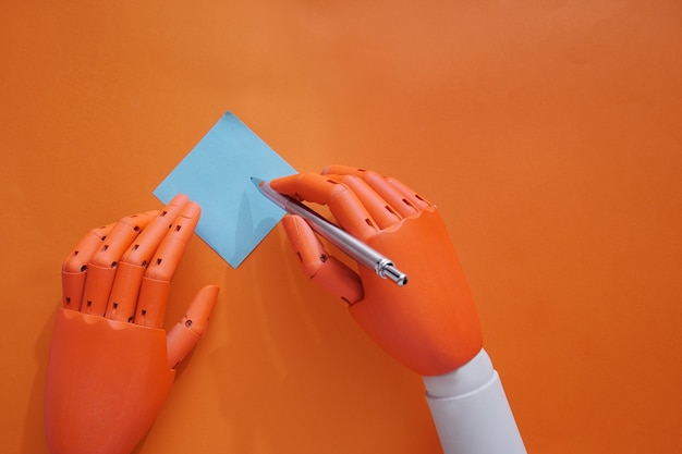 Foto las manos del maniqu hacen una nota sobre un fondo naranja