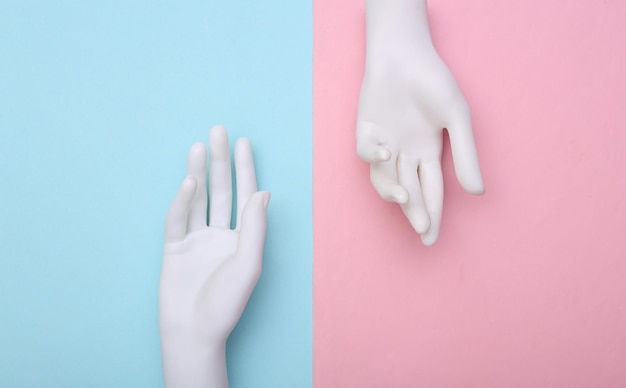 Manos de maniquí blanco sobre fondo azul rosa. Minimalismo. Arte conceptual