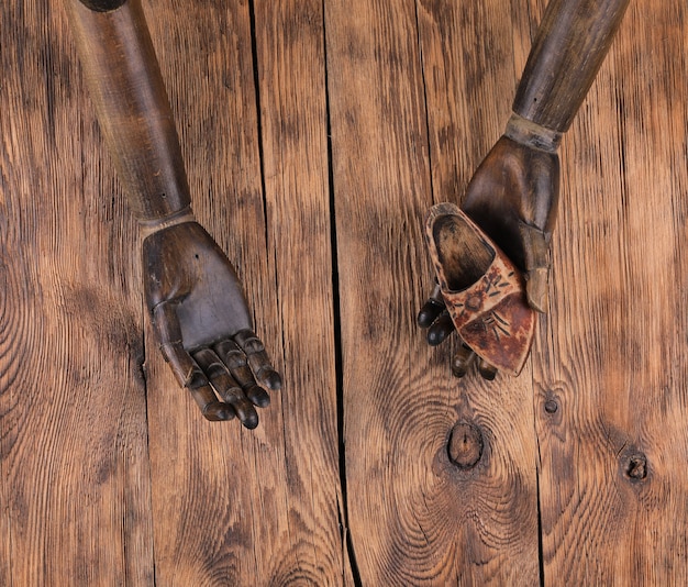 Manos de maniquí de madera antigua sobre fondo de madera