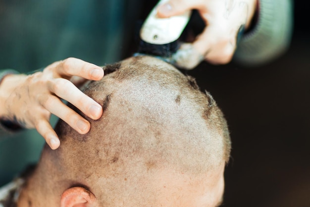 Manos masculinas cabeza de afeitado de un cliente