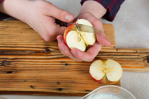 Manos masculinas cortan una manzana en rodajas