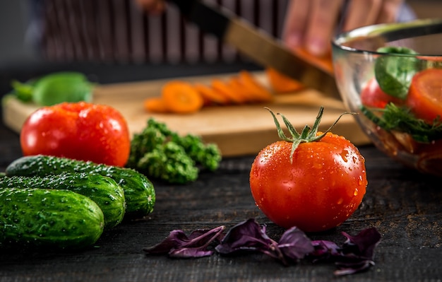 Manos masculinas cortando verduras para ensalada