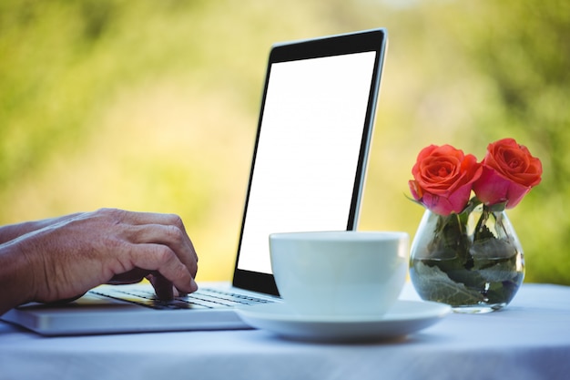 Manos masculinas escribiendo en una computadora portátil