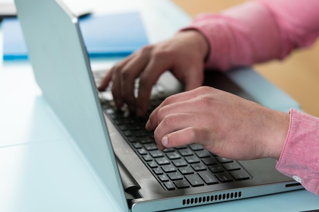 Manos masculinas escribiendo en el teclado de la computadora portátil