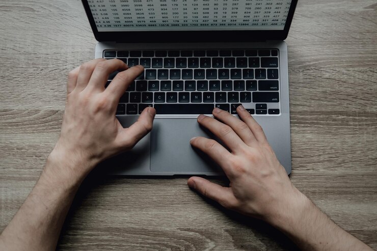 Foto las manos masculinas están escribiendo en un teclado de portátil. el hombre de negocios trabaja remotamente desde casa como freelance en línea.
