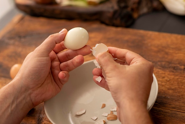 manos masculinas pelan huevos cocidos