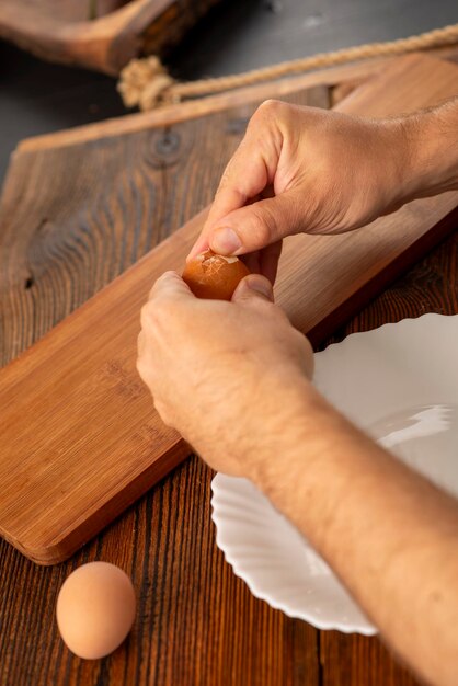 Foto manos masculinas pelando un huevo cocido en la cocina tiro natural