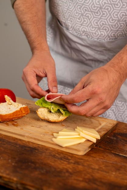 Foto manos masculinas preparando una hamburguesa en casa