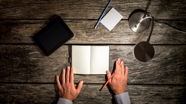 Manos masculinas a punto de tomar notas en el cuaderno en blanco