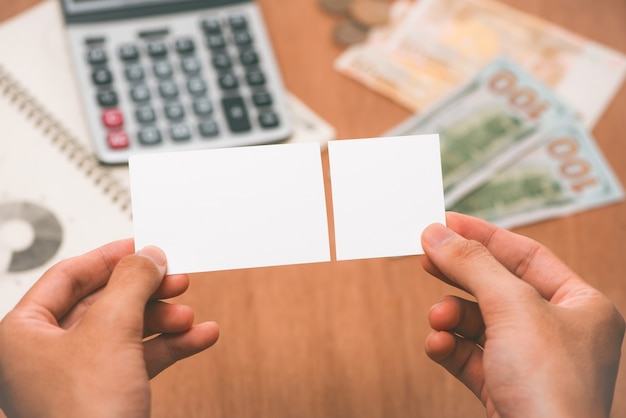 Manos masculinas sosteniendo dos trozos de papel en blanco