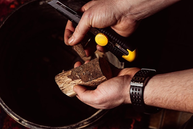 Manos masculinas tallan madera con un cuchillo