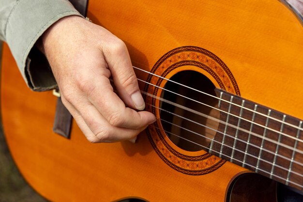 Manos masculinas tocando la guitarra acústica de cerca El maestro está dando una lección de guitarra