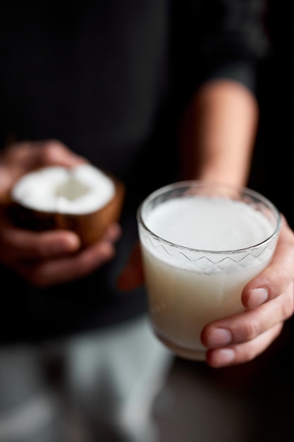 Manos masculinas con vaso de leche de coco vegana Tipos alternativos de leches no lácteas leche vegetal hecha de varios granos Comida limpia Dieta saludable