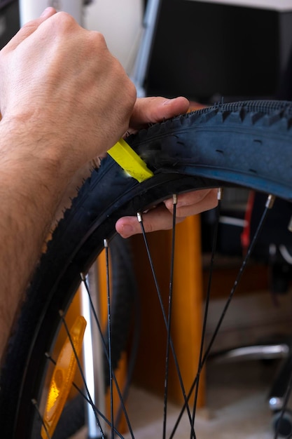 Manos de un mecánico que ajusta la rueda de una bicicleta