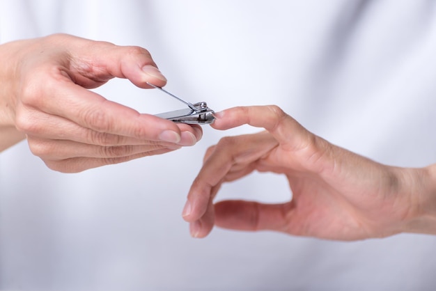 Manos de mujer adulta cortando uñas cortaúñas manicura en casa cuerpo carexA