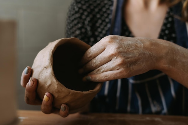 Las manos de la mujer alfarera trabajan con arcilla. Hacemos un cuenco de arcilla moldeando el concepto de hobby femenino.