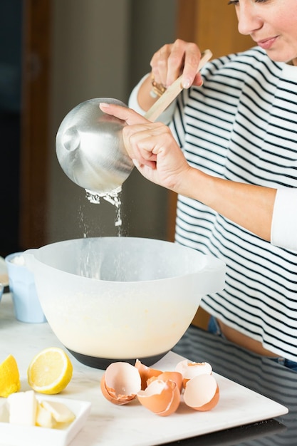 Manos de mujer amasando la masa mientras cocina tarta de manzana