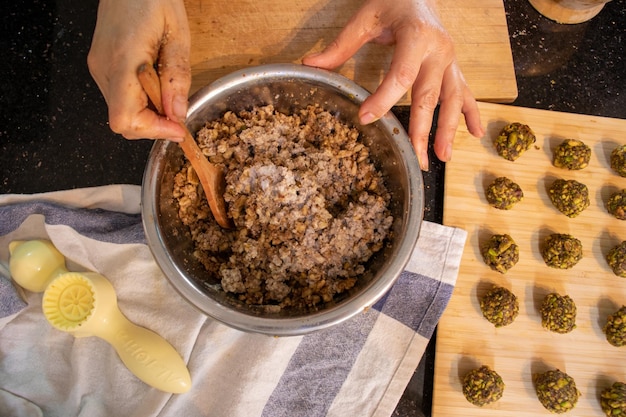 Manos de mujer árabe mientras prepara ingredientes para keto kahk en casa