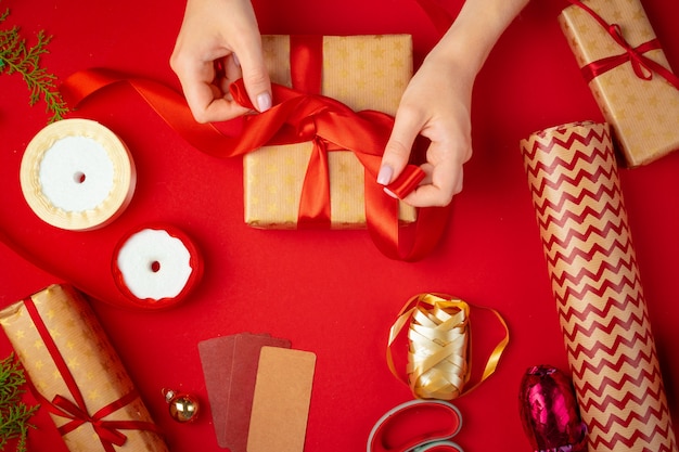 Manos de mujer con caja de regalo de Navidad en rojo