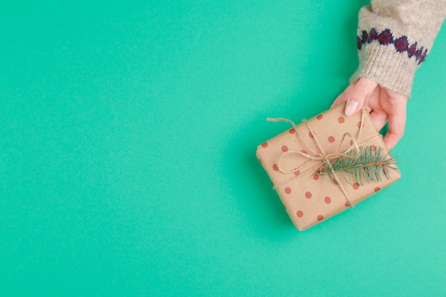 Manos de mujer con caja de regalo en verde