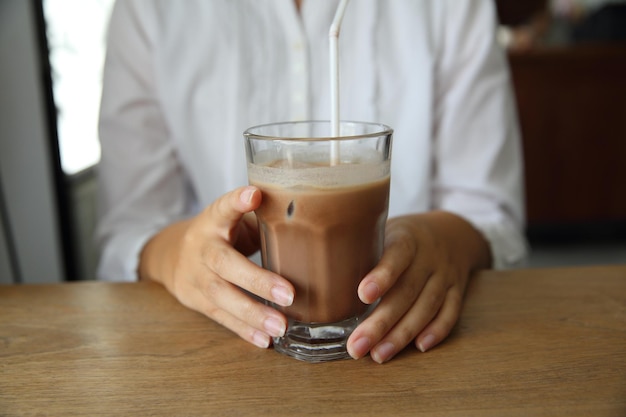 Manos de mujer con chocolate helado en una mesa de madera