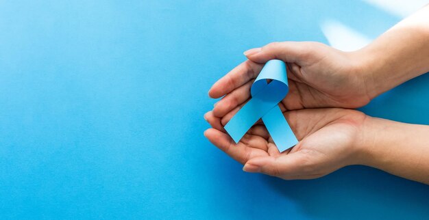 Manos de mujer con cintas azules Concientización sobre el cáncer de próstata Concepto de atención médica masculina