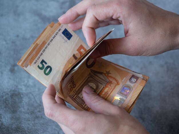 Foto manos de mujer contando dinero billetes de cincuenta euros inflación contabilidad economía doméstica