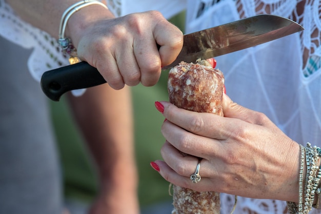 Manos de mujer cortando salami