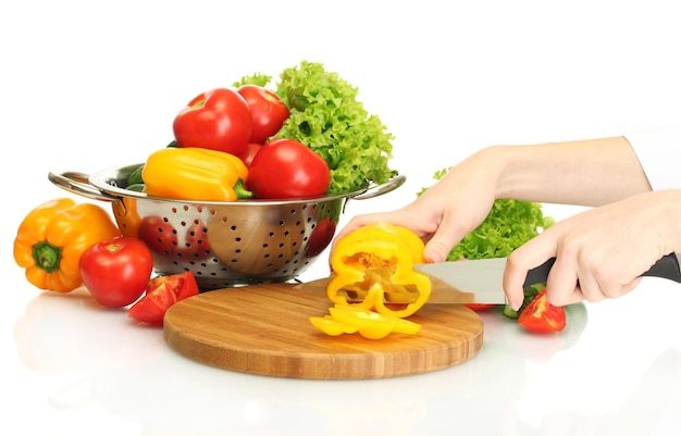 manos de mujer cortando verduras en la pizarra de la cocina