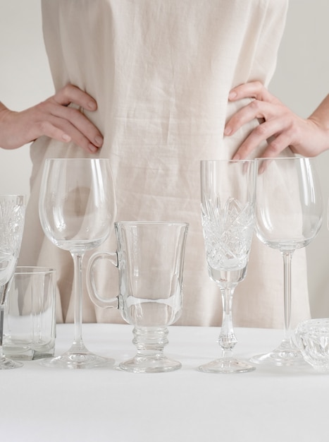 Foto manos de mujer con diferentes copas de vino sobre la mesa en el blanco