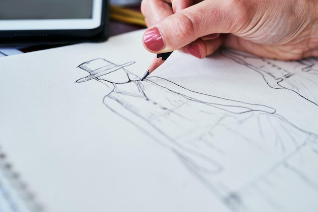 Foto manos de mujer y diseño de moda primer plano de dibujar en papel en la idea de planificación o dibujar en el escritorio mano de una artista creativa o diseñadora gráfica para ideas de bocetos de ropa para el inicio