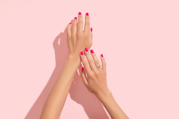 Foto manos de mujer con diseño de uñas rosa manicura pedicura salón de belleza concepto sombras largas y profundas