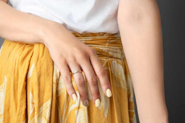 Manos de mujer con diseño de uñas amarillo brillante.