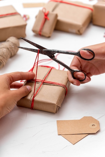 Manos de mujer envolviendo cajas de regalo de Navidad