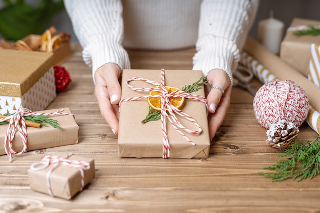 Manos de mujer envolviendo regalo de Navidad