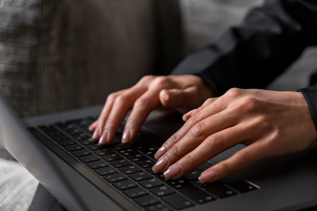 Manos de mujer escribiendo en el teclado de la computadora portátil