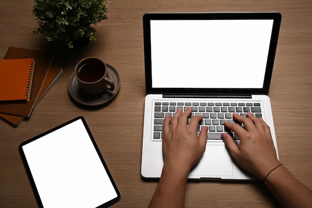 Manos de mujer escribiendo en el teclado de la computadora portátil