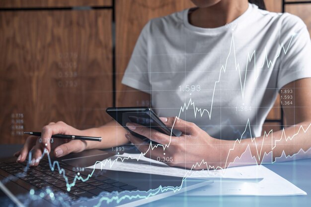 Manos de mujer escribiendo el teclado para investigar el mercado de valores para proceder con soluciones de inversión correctas Comercio por Internet y concepto de gestión de riqueza Ropa informal Holograma Gráfico de Forex sobre toma de primer plano