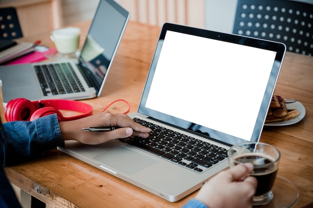 Foto manos de mujer escribiendo en el teclado del ordenador portátil con pantalla en blanco blanco con