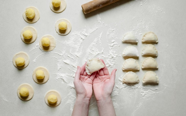 Foto manos de mujer esculpe albóndigas con patatas. comida tradicional ucraniana