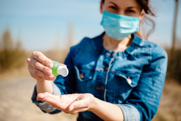 Manos de mujer con gel desinfectante para manos. Manos de mujer con dispensador de bomba de gel desinfectante para manos.