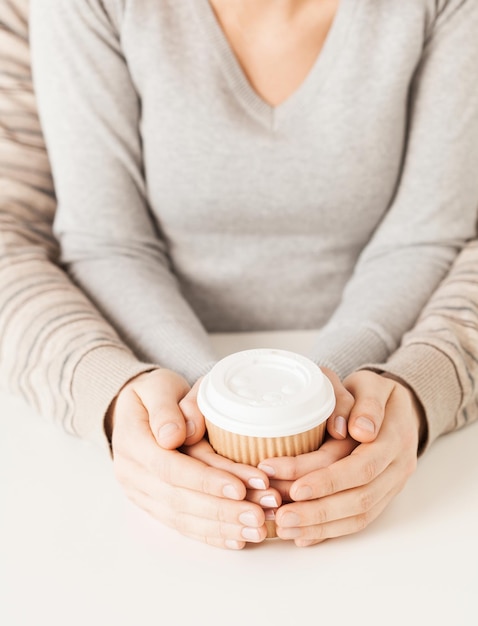 manos de mujer y hombre sosteniendo una taza de café para llevar