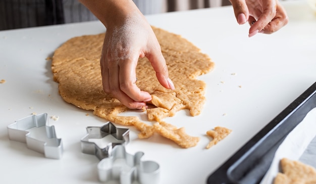 Manos de mujer para hornear galletas en la cocina