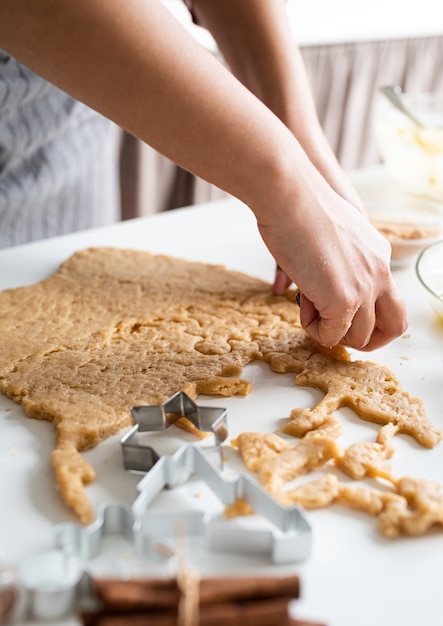 Manos de mujer para hornear galletas en la cocina