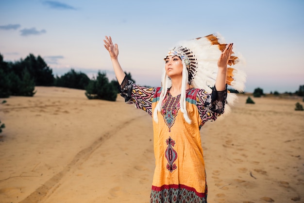 Manos de mujer indígena americana, ritual, ceremonia ritualista Cherokee, gente de la reserva Navajo. Tocado de plumas de aves silvestres