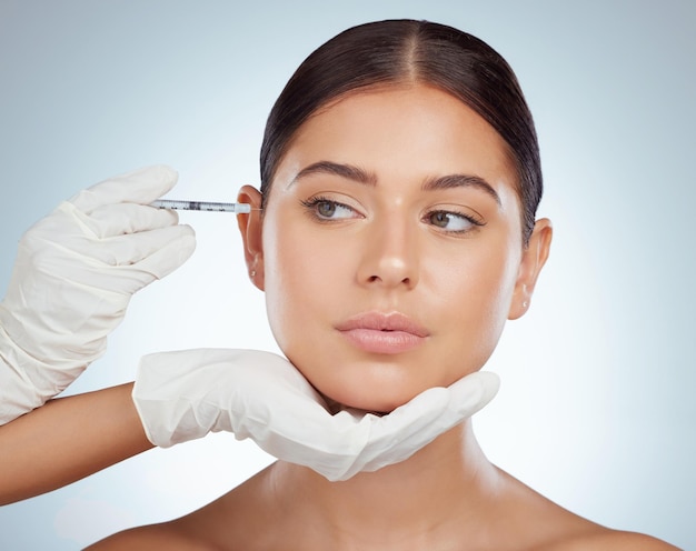 Manos de mujer y inyección para antienvejecimiento en estudio sobre fondo blanco confiada en la dermatología Agua de persona femenina y lifting facial o rellenos como tratamiento para el cuidado de la piel y la belleza con estética